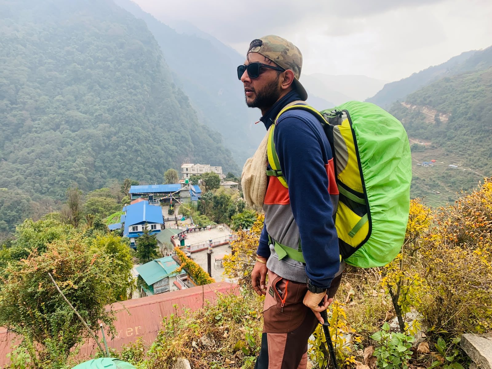 Trekker overlooking a village on the way to Annapurna Base Camp