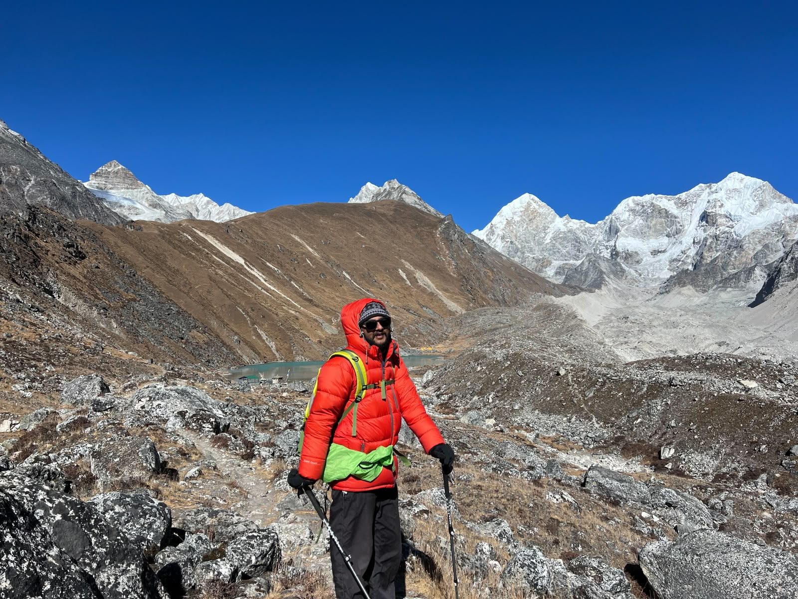 Trekker in red jacket with Himalayan peaks behind, Rolwaling